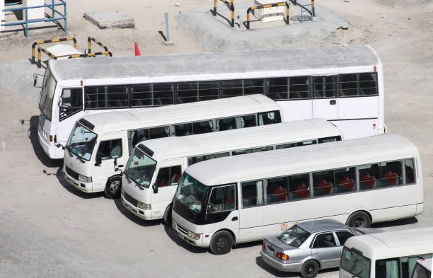 Dubai, UAE - November 17, 2018: Small suburban buses Toyota Coaster and Mitsubishi Fuso Rosa in the city street.